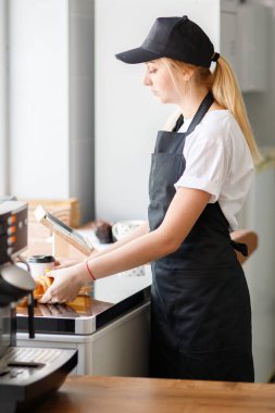 Güzel kız kahve ve hamur işi satıyor.