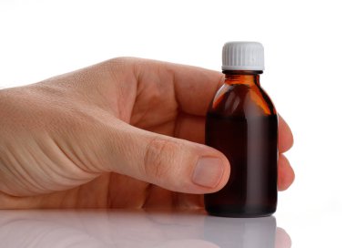 Elinde bir kavanoz ilaç var.