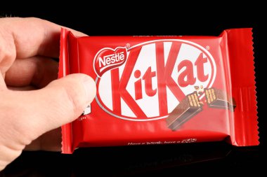 LVIV, UKRAINE - 27 Nisan 2020: Kit Kat tatlıları ellerinde siyah arkaplan