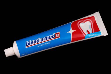 LVIV, UKRAINE - 09 Nisan 2020: Siyah arkaplanda tıbbi diş macunu harmanlama