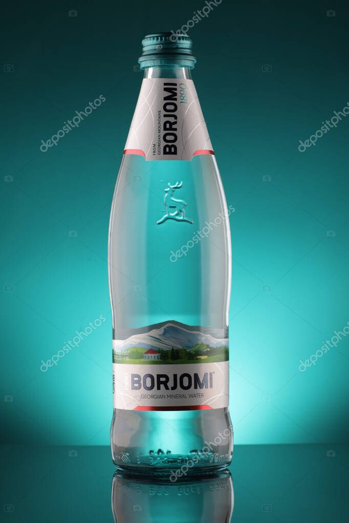 LVIV, UKRAINE - April 09, 2020: Mineral water Borjomi in glass bottle on blue background