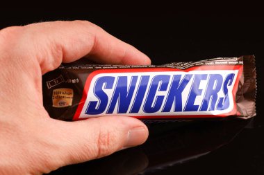 LVIV, UKRAINE - Nisan 06, 2020: Siyah arka planda Snickers