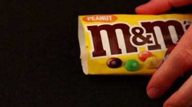 LVIV, UKRAINE - Nisan 06, 2020: LVIV, UKRAINE - Nisan 06, 2020: M & Ms hapları paket siyah arkaplanından döküldü