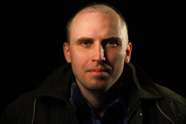 Orta yaşlı kel bir adamın portresi.