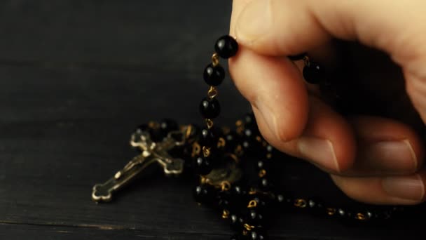 祈りを捧げる人の手によるカトリックのロザリオ — ストック動画