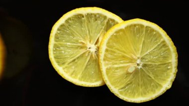 Siyah arka planda birkaç dilim limon.