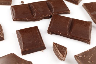 Beyaz arkaplandaki siyah çikolata parçaları...