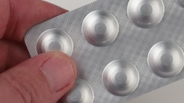 Medicines in a blister hold a person's hands.