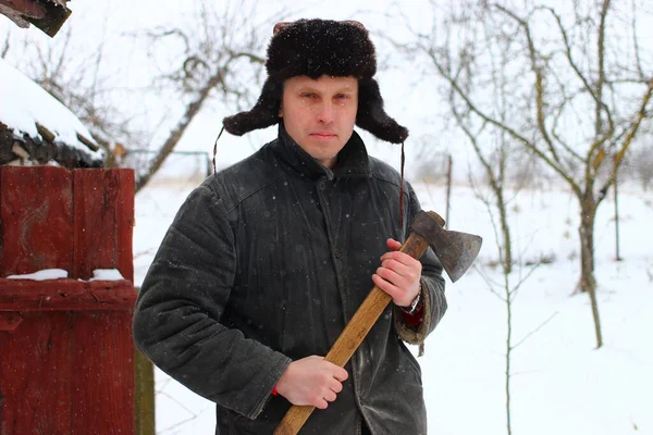 stock image Poor young peasant in winter with an ax