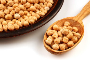 Bir tabakta nohut ve beyaz bir arka planda kaşık