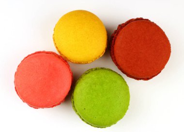 Beyaz arka planda birkaç tane Macaron kurabiyesi.