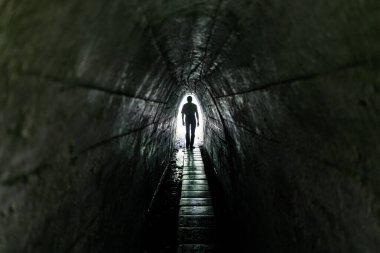 Karanlık bir tünelde yoldan geçen yalnız bir adam. Tünelin sonunda ışık var..