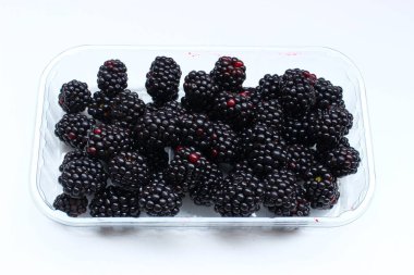 Beyaz arka planda sepetin içinde ağır meyveler.