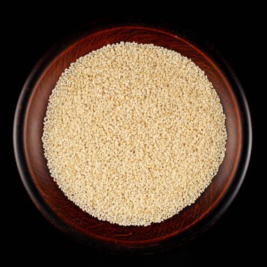 Siyah arkaplanda bir tabakta susam tohumları