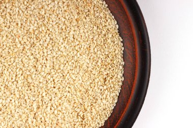 Beyaz arkaplanda bir tabakta susam