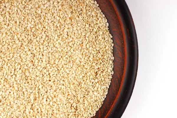 Beyaz arkaplanda bir tabakta susam