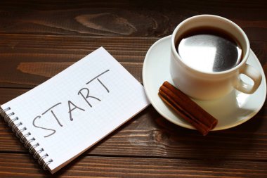 Bir fincan kahvenin yanındaki deftere yazıyı ve kelimeyi yazmaya başla.