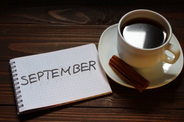 Eylül yazıtları ve kelimeler bir kahve fincanının yanındaki deftere yazılmış.