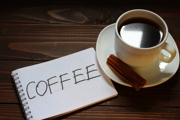 コーヒーカップの近くのノートにコーヒーの銘文と単語 — ストック写真