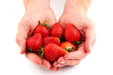 Beyaz arka planda bir adamın ellerinde ya da avuçlarında çilekler