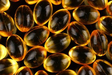 Kapsüllerdeki balık yağı siyah bir arkaplanda.