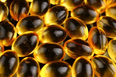 Siyah arka planda kapsüllerdeki balık yağı