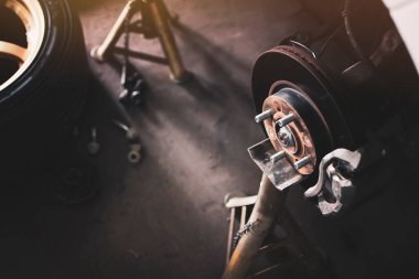 Araba tamir atölyesinde tekerleksiz fren diski sistemi tamir edilmeyi bekliyor.