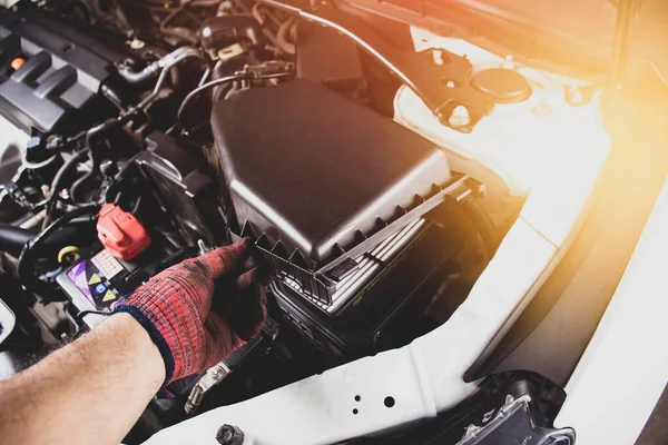 The mechanic is opening the engine air filter of a car , automotive part concept