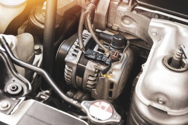Benzin motorunda otomobil alternatörü, araba motorunun elektrik şarj sisteminin bileşeni, otomotiv parçası konsepti.