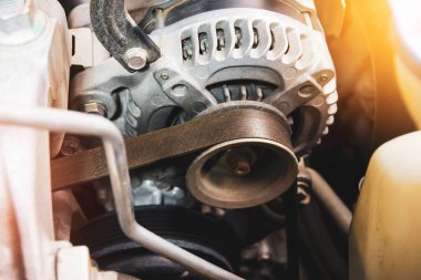 Benzin motorunda araba alternatörünün zaman kayışı, araba motorunun elektrik şarj sisteminin bileşeni, otomotiv parçası konsepti
