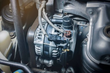 Benzin motorunda otomobil alternatörü, araba motorunun elektrik şarj sisteminin bileşeni, otomotiv parçası konsepti.