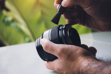 Kameranın objektifindeki insan tozu kalem fırçası temizleyicisiyle temizleniyor