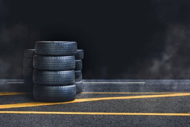 Gece dumanlı asfalt yolda lastik yığını ve siyah arkaplan, boşluğu kopyala