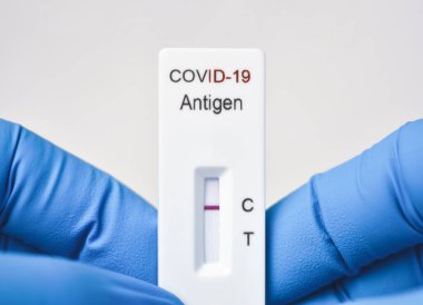Beyaz arka plandaki antijen hızlı test kitinin negatif sonuçlarını gösteren tıbbi personel, Coronavirus bulaşıcı koruma kavramı