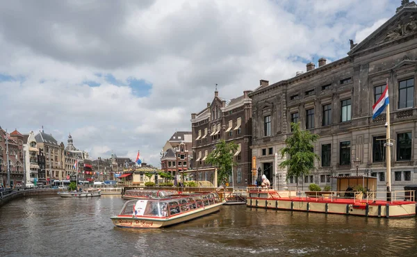 Amsterdam, Hollanda 23 Haziran 2021 - Şehrin merkezindeki Damrak Kanalı bir kanal turdan sonra turistleri geri getiriyor.