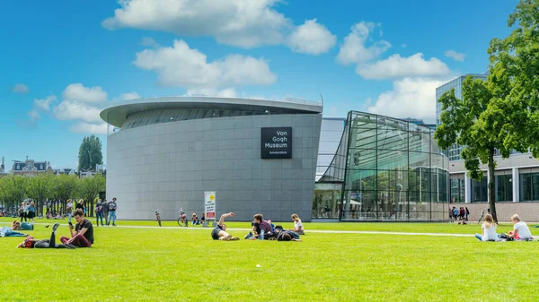 Amsterdam, Hollanda - 23 Temmuz 2020 - Van Gogh Müzesi 'ndeki müzenin çimlerinde oturan turistler