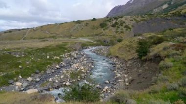 Torres del Paine Ulusal Parkı 'ndaki küçük bir nehrin yanında yürüyen yürüyüşçü Torres del Paine, Şili, 3 Mart 2019