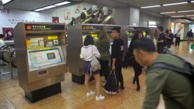 Yerel halk ve turistler Mong Kok metro istasyonundan bilet alıyorlar.