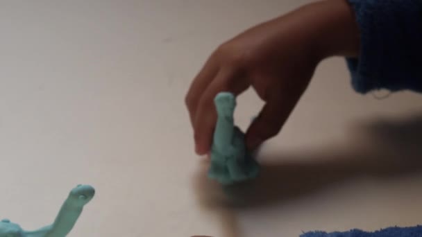Criança Brincando Com Figuras Barro Dinossauro Azul Mesa Branca Conceito — Vídeo de Stock