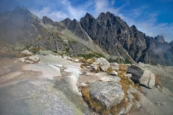 Velka Studena dolina, High Tatras - stones by the tourist trail with the background of Tatra peaks during the hike to Zbojnicka chata. — 图库照片