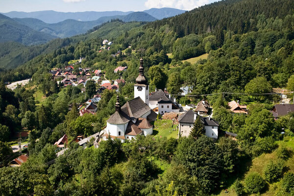 The Spania Valley village, Slovakia: a view on the surrounding famous mining village. An older houses, trees, church and mountains.