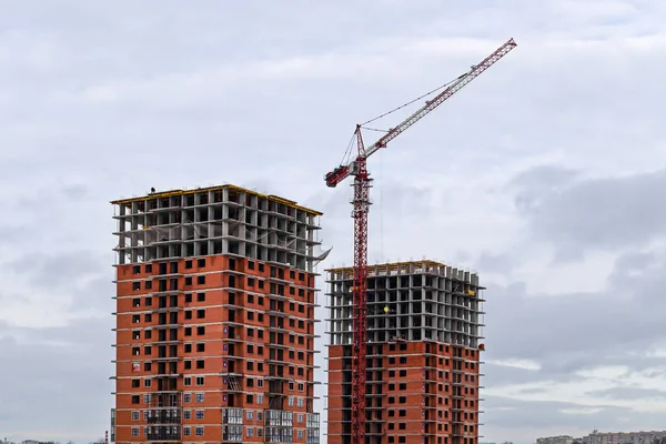 Construction of a modern residential high-rise building with a crane.