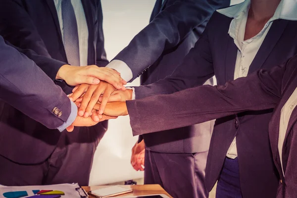 Business people hold hands together as a teamwork