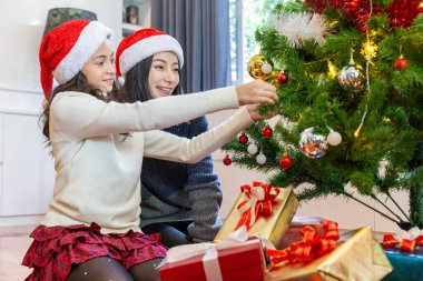 Anne ve kızı Noel tatili boyunca Noel ağacını süsler.