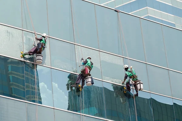 Kelompok pekerja membersihkan layanan jendela pada bangunan tinggi — Stok Foto