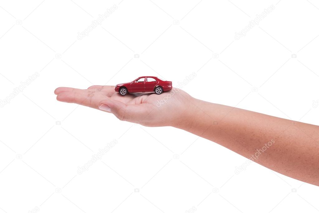 Mobil model merah di  tangan  terisolasi di  latar belakang 