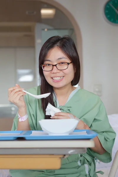 Asiatisk tjej patienten njuter måltid i sjukhussäng — Stockfoto