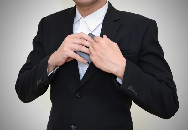 Handsome businessman reaching into his coat pocket to get his wallet. — Stock Photo, Image