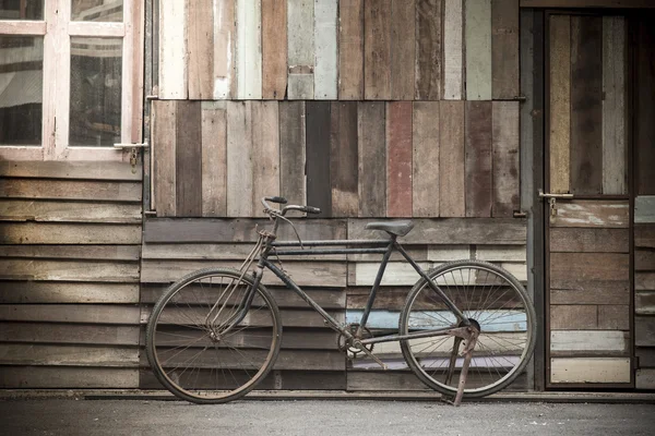 Rower starodawny stojący w pobliżu drewna ściana — Zdjęcie stockowe