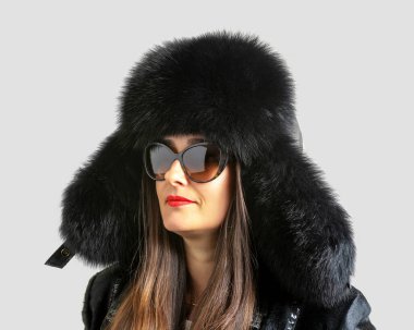 Parlak bir arka planda kürk şapkalı güzel bir kadın. Kış modası geçmişi.